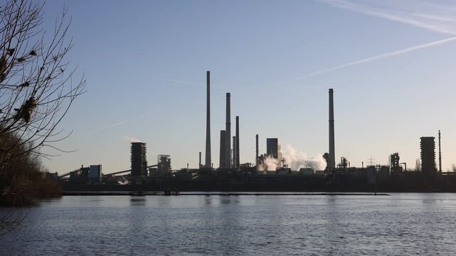 Wide riverbank view of coking plant at sunrise