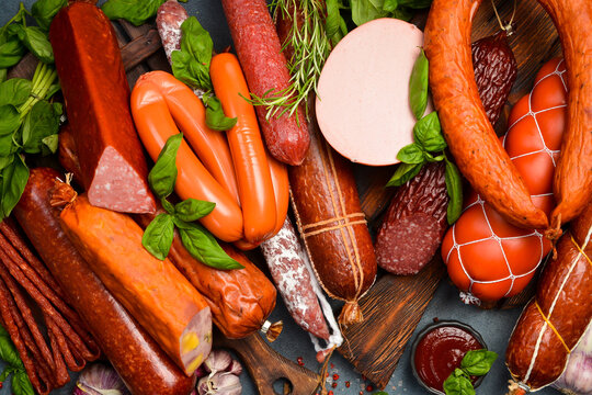 Different types of tasty sausages on grey table, flat lay