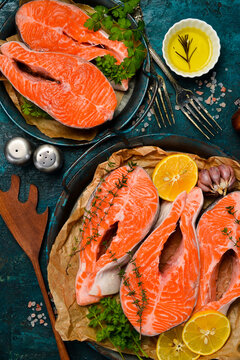 Fresh raw salmon steaks on a metal tray, ready to be cooked. Top view. Vertical photo.