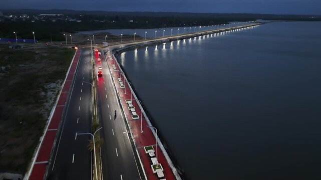 Aerial drone view of a road bridge with cars and lights in Sorsogon City Coastal Road West, Bicol, Philippines