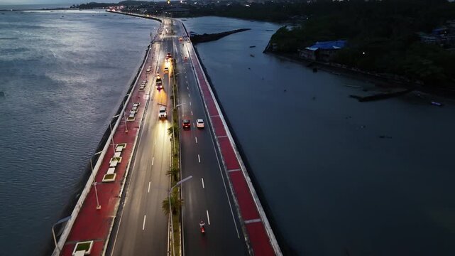 Aerial drone view of a road bridge with cars and lights in Sorsogon City Coastal Road West, Bicol, Philippines