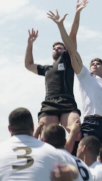 Rugby, match and team outdoor with lift, fitness exercise and athlete catch ball for tournament game. Sports, player and men support with lineout jump, wellness and collaboration for competition.