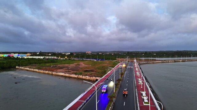 Aerial drone view of a road bridge with cars and lights in Sorsogon City Coastal Road West, Bicol, Philippines