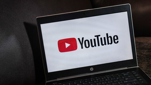 Laptop computer screen displaying the youtube logo on a dark background with hp branding visible