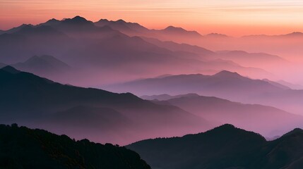 Obraz premium Misty mountain landscape bathed in warm sunset hues creates a serene and dramatic atmospheric scene