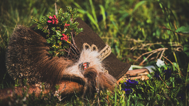 a traditional hunting hat with a chamois beard, a juniper twig and blossoms of alpine rose after the happy hunt, at a sunny spring morning
