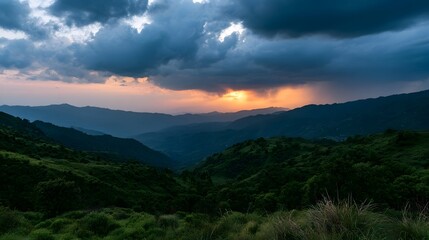 Fototapeta premium A dramatic panoramic view of rugged mountain ranges bathed in the warm glow of a vibrant sunset