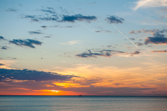 Beautiful sundown background with calm sea and cloudy sky