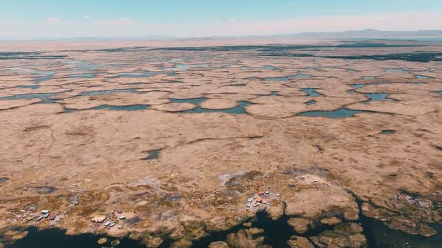 Drone view of the Uros Floating Islands on Lake Titicaca, Peru. Traditional reed islands preserve the unique culture and heritage of the Uros people.
