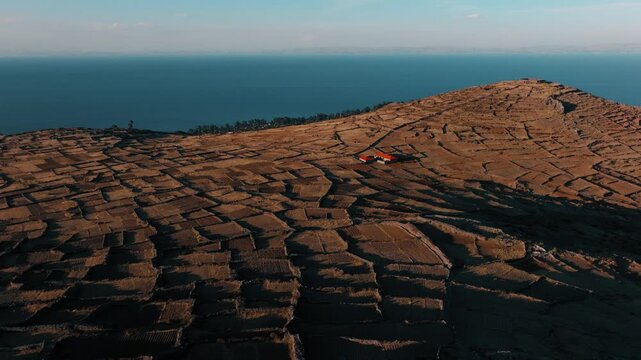 Drone view of ancient agricultural terraces overlooking Lake Titicaca on Isla del Sol, one of Bolivia&rsquo;s most iconic cultural landscapes.