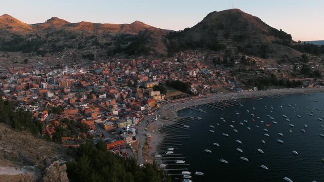Drone view of Copacabana, a lakeside town on Lake Titicaca in Bolivia. Colorful buildings spread between the mountains and the waters of the iconic Andean lake.