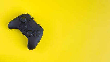 Blank black gamepad controller mockup on yellow background with negative space for gaming design.  © wibiwisnu