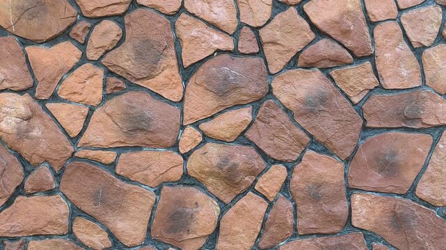 A modern wall features a random pattern of faux stones. Crafted from cement and concrete, they are realistically painted. This durable cladding delivers a stylish, rustic architectural finish.