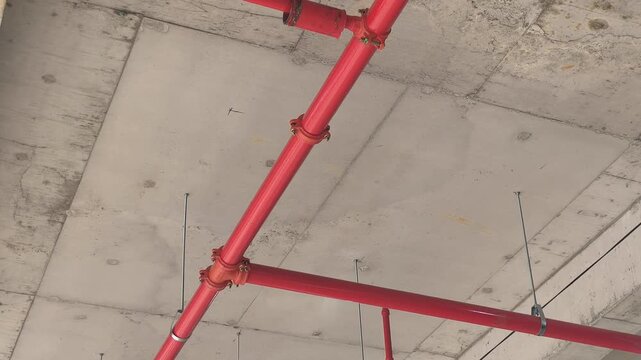 Workers install a fire sprinkler pipe network at a construction site. Fabricated to precise engineering designs, this vital system delivers water to suppress initial blazes before firefighters arrive.