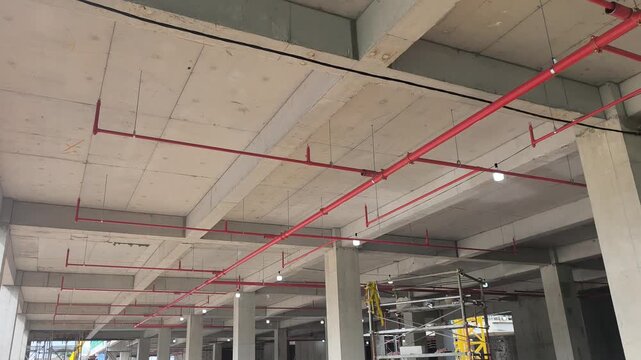 Workers install a fire sprinkler pipe network at a construction site. Fabricated to precise engineering designs, this vital system delivers water to suppress initial blazes before firefighters arrive.