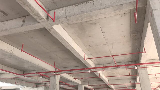 Workers install a fire sprinkler pipe network at a construction site. Fabricated to precise engineering designs, this vital system delivers water to suppress initial blazes before firefighters arrive.