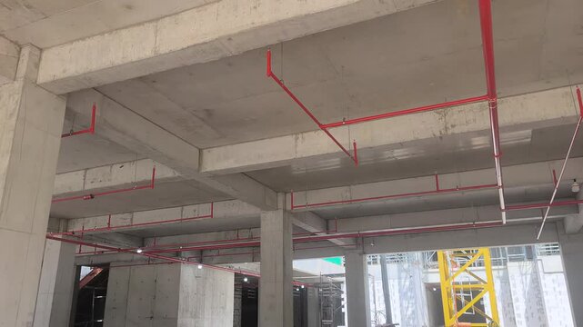 Workers install a fire sprinkler pipe network at a construction site. Fabricated to precise engineering designs, this vital system delivers water to suppress initial blazes before firefighters arrive.