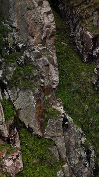 Man athlete climbing on the high rock in the mountains