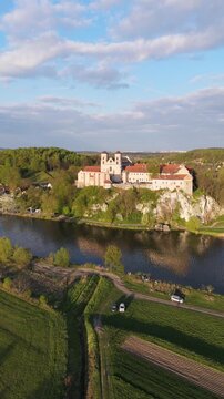  Aerial flyover of an abbey on a river in Poland at sunset in spring