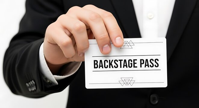 A hand, dressed in suit, holding a white card that reads "BACKSTAGE PASS