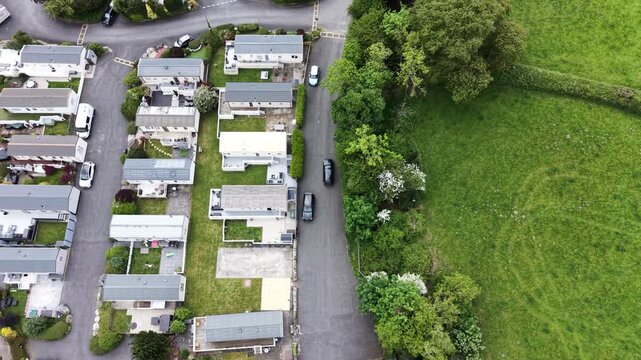 A drifting aerial clip showing caravans positioned along hillside vegetation.