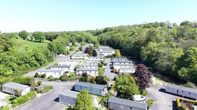 A warm aerial scene showing caravans placed within countryside vegetation.