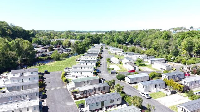 A wide aerial clip showing caravans arranged within valley vegetation.