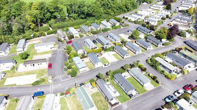 A wide aerial clip showing caravans extending toward a green horizon beneath bright daylight.