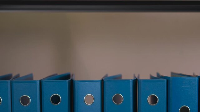 Blue office binders arranged on a shelf