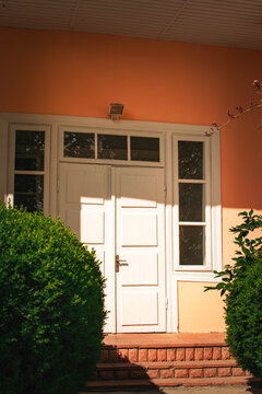 classic white double entrance door with landscaped building facade
