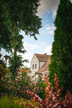 cozy two-story country house surrounded by lush garden on sunny summer day