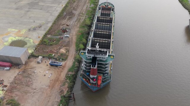 Buque mercante atracado en una terminal portuaria para el traslado de bienes, comercio internacional, operaciones mar&iacute;timas, log&iacute;stica global, abastecimiento e industria naval