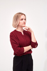 Obraz premium A young woman in a maroon blouse poses in a studio against a white background.