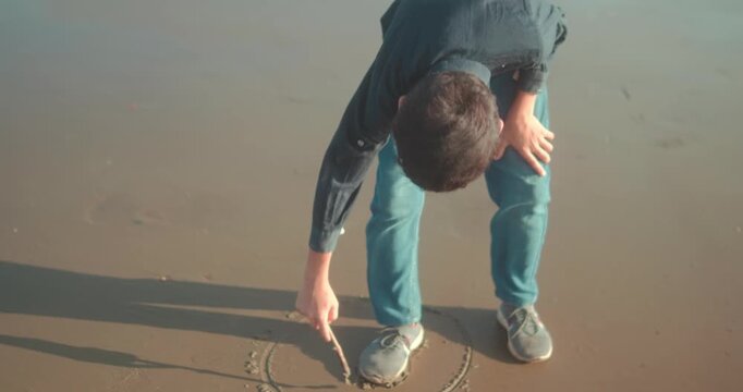 Man bending over, using a stick to draw a perfect circle on the wet beach sand, symbolizing personal space, mindfulness, and the concept of setting limits