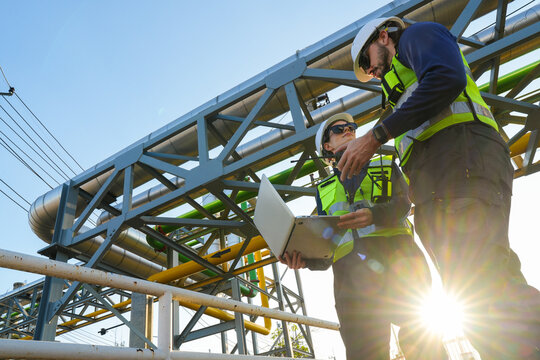 Engineering project team conducting a critical site audit and schematic review of pipeline infrastructure to verify system specifications and operational compliance.