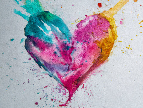 Vibrant multicolored watercolor heart artwork blending bold pink, turquoise, and golden tones with dynamic splashes on textured paper background for creative designs