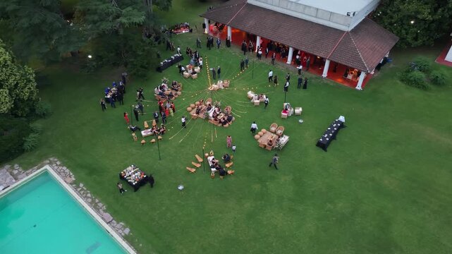 Evento social en una estancia al atardecer con gente celebrando, casamiento, festejo, festividad, reuni&oacute;n al aire libre, ambiente campestre y celebraci&oacute;n elegante