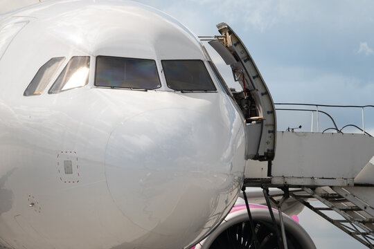Airplane cockpit nose close up with open door and stairs