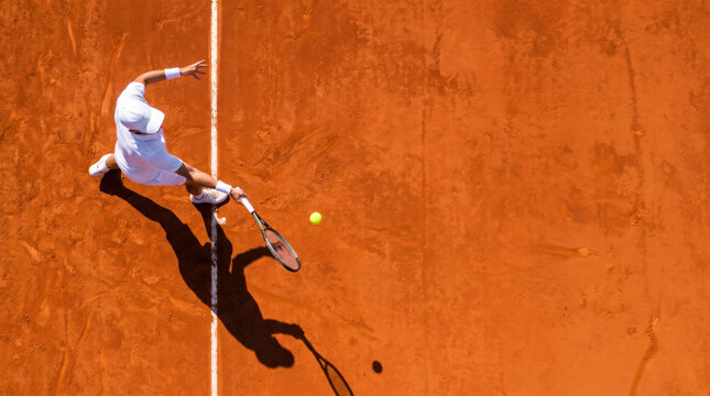Aerial view of tennis athlete in motion on clay court, dramatic top down sports composition capturing powerful shot, agility, precision and athletic performance during match play