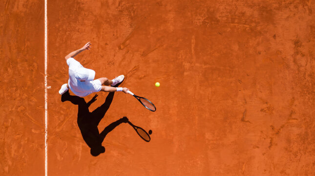 Drone perspective of professional tennis player competing on red clay court, striking overhead sports action showcasing movement, agility, precision and athletic performance during match play