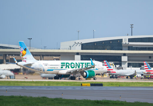 Frontier Airlines aircraft Airbus A320 taking off at the Dallas Fort Worth International Airport (DFW). Cookie the Oriole livery.