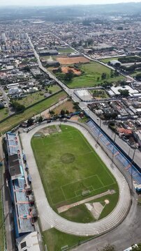 Drone registra est&aacute;dio de futebol em Suzano evidenciando a estrutura esportiva e o campo cercado por arquibancadas no munic&iacute;pio paulista.