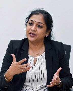 South Asian businesswoman speaking in corporate office interview about equality and inclusion, middle aged corporate worker
