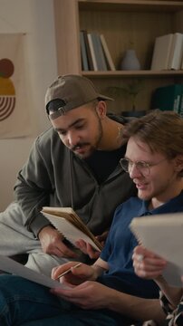 Vertical of diverse young male and female students studying together, doing homework, man explaining math problem to flatmates. Educational marketing or student lifestyle campaigns