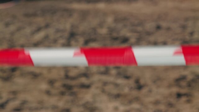 Blurred closeup of red and white striped barrier tape. Industrial safety concept. Caution warning line. Restricted area marker