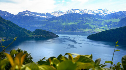 Naklejka premium Scenic view from Rigi Kaltbad overlooking Lake Lucerne, surrounded by lush greenery and majestic mountains under a clear blue sky with snow-capped peaks