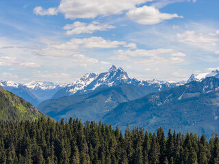 Obraz premium Snow-Capped Mountain Range And Alpine Forest Under Blue Sky In Fraser Valley Chilliwack BC Canada