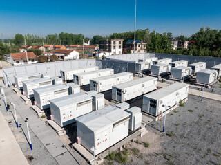 Obraz premium outdoor energy storage power station with rows of white container units under blue sky