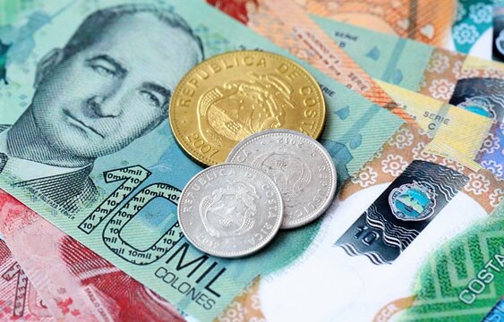 Costa Rican colon money bills and coins on table. Costa Rica cash of CRC currency close up