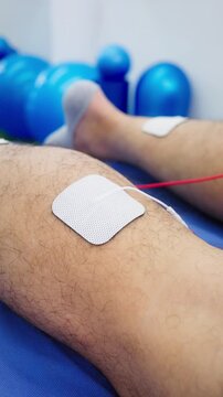 Close-up of electrotherapy for muscle strengthening in adult legs